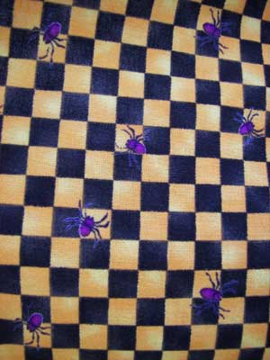 Close up of Hokus Pokus black orange gingham with purple spiders